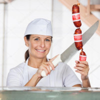 depositphotos61630975-stock-photo-female-butcher-cutting-sausages-at